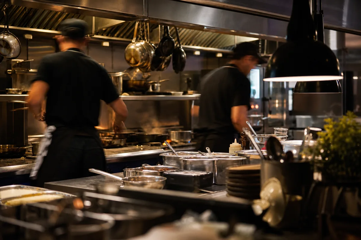 Cuisine de brasserie basque en pleine préparation avec plusieurs cuisiniers au poste